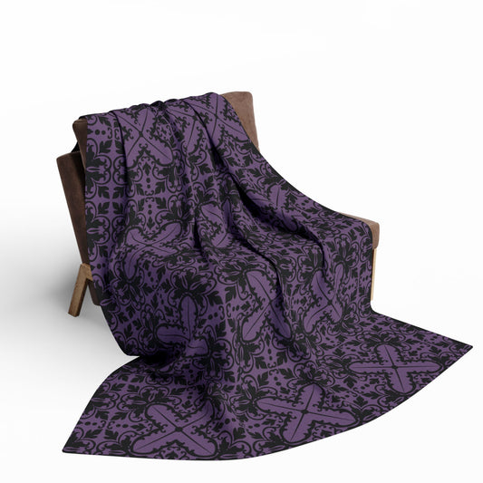 Purple blanket with a black damask pattern with gothic vibes draped over a chair