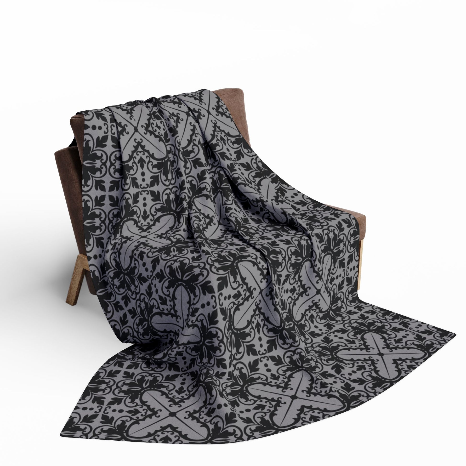 large grey blanket with a black damask gothic style pattern draped over a chair

