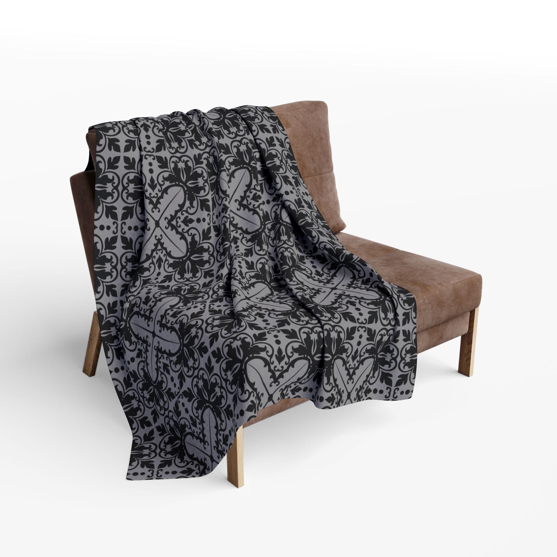 medium grey blanket with a black damask gothic style pattern draped over a chair

