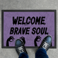 Welcome Brave Soul Horror Doormat with Zombie Hands – Grungy Light Purple Halloween Decor