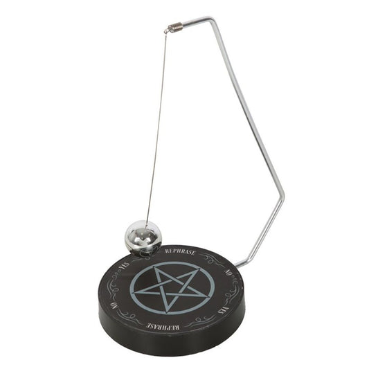 A pendulum decision maker hanging over a board with a pentagram and "yes" , "no", "maybe" and "rephrase" printed on it