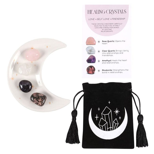 An image of a white half moon trinket dish with golden stars containing each of the 4 crystals available along with the small black velvet pouch with a moon and crystals on it