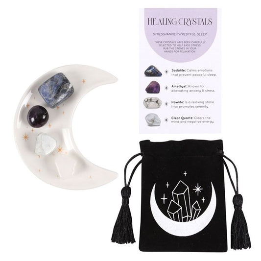 An image of a white half moon trinket dish with golden stars containing each of the 4 crystals available along with the small black velvet pouch with a moon and crystals on it