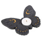 A black moth shaped tea light holder with gold stars and moons on it's wings
