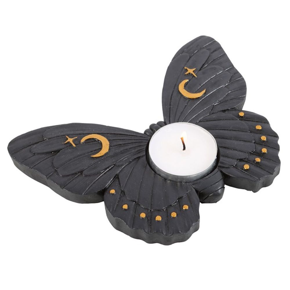 A black moth shaped tea light holder with gold stars and moons on it's wings