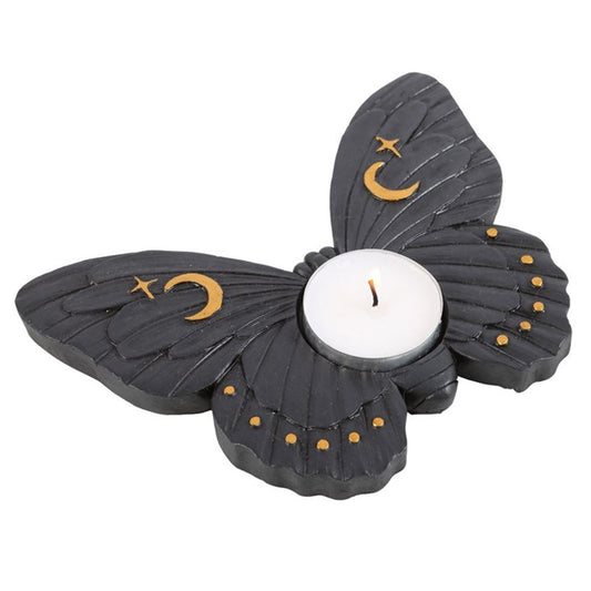 A black moth shaped tea light holder with gold stars and moons on it's wings